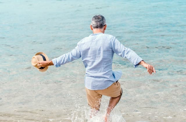 A man splashing into the ocean on a sunny day