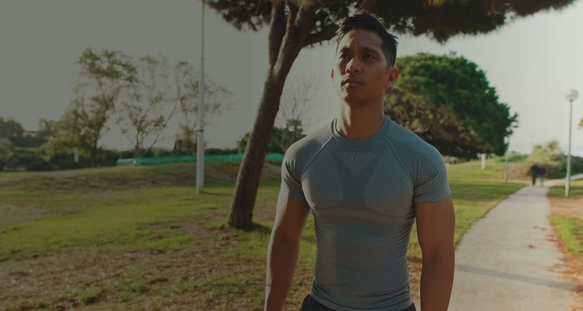 A fit man walking in a park