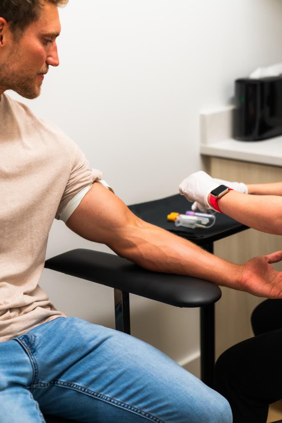 A clinician prepares a patient for a blood draw