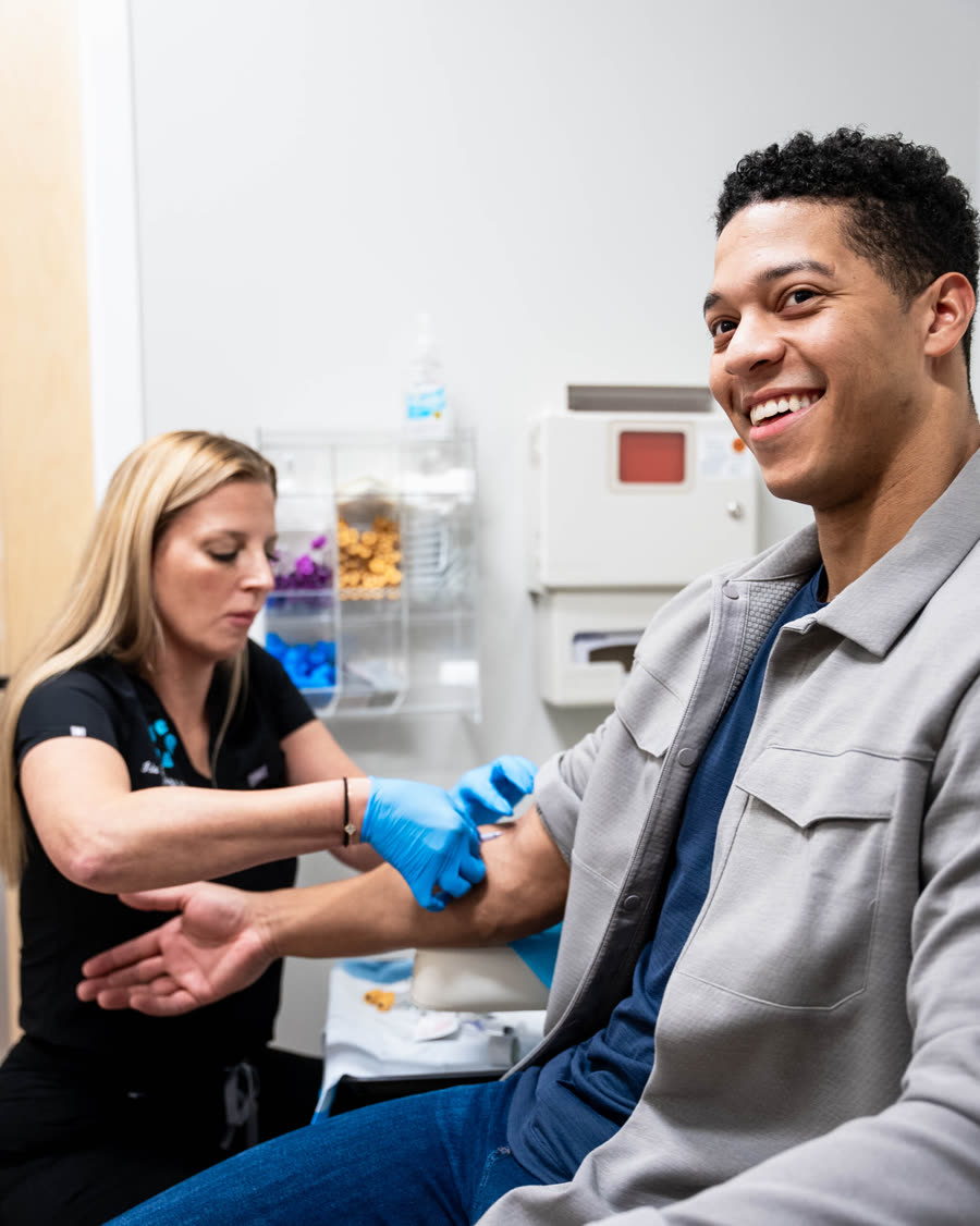 A smiling man has blood drawn by a Relive Health clinician